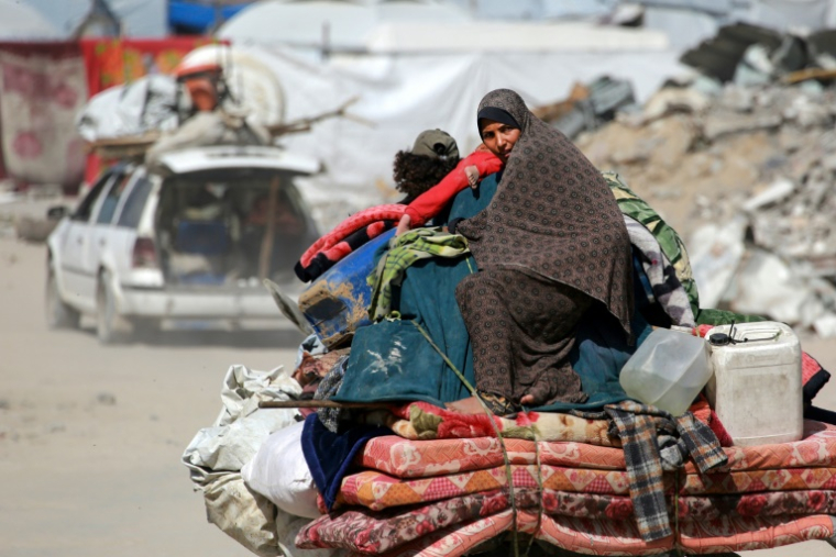 Des Palestiniens transportant quelques biens fuient la villede Gaza, le 16 mai 2025 ( AFP / Bashar TALEB )