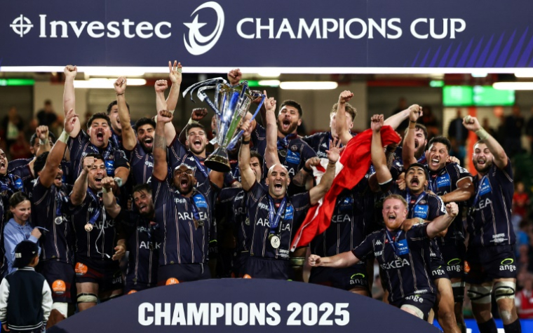 Le pilier de l'UBB Jefferson Poirot (G) et le demi de mêlée  Maxime Lucu (D) soulèvent la Champions Cup après leur victoire en finale face à Northampton, à Cardiff, le 24 mai 2025 ( AFP / Anne-Christine POUJOULAT )