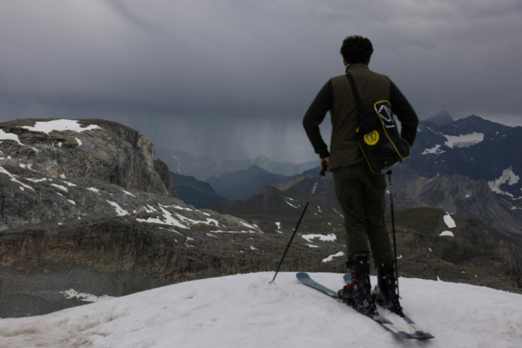 Un skieur regarde le paysage depuis le sommet d'une piste rouge, le 11 juillet 2026 à Tignes, en Savoie ( AFP / Alex MARTIN )
