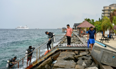 Un touriste, accompagné de guides, revient d'une plongée en mer ouverte près de la plage de Rasfannu à Malé, le 15 mai 2026 ( AFP / Mohamed Afrah )