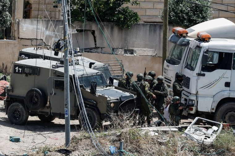 De nombreux soldats israéliens arrêtent un homme palestinien lors d'un raid en Cisjordanie occupée