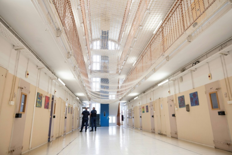 Des gardiens de prison se tiennent à côté des cellules du Centre National d'Évaluation (CNE), une installation dédiée à l'évaluation de la personnalité et du risque potentiel des détenus, à la prison de Fresnes, à Fresnes, au sud de Paris, le 15 mai 2025 ( AFP / Thomas SAMSON )
