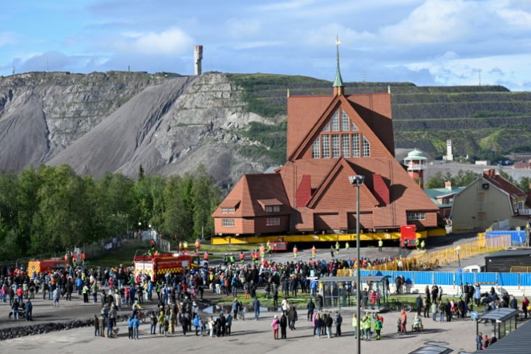 Des personnes assistent au déplacement de l'église en bois de Kiruna, le 19 août 2025 à Kiruna, en Suède ( TT NEWS AGENCY / Fredrik SANDBERG )