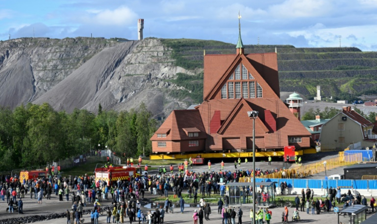 Des personnes assistent au déplacement de l'église en bois de Kiruna, le 19 août 2025 à Kiruna, en Suède ( TT NEWS AGENCY / Fredrik SANDBERG )