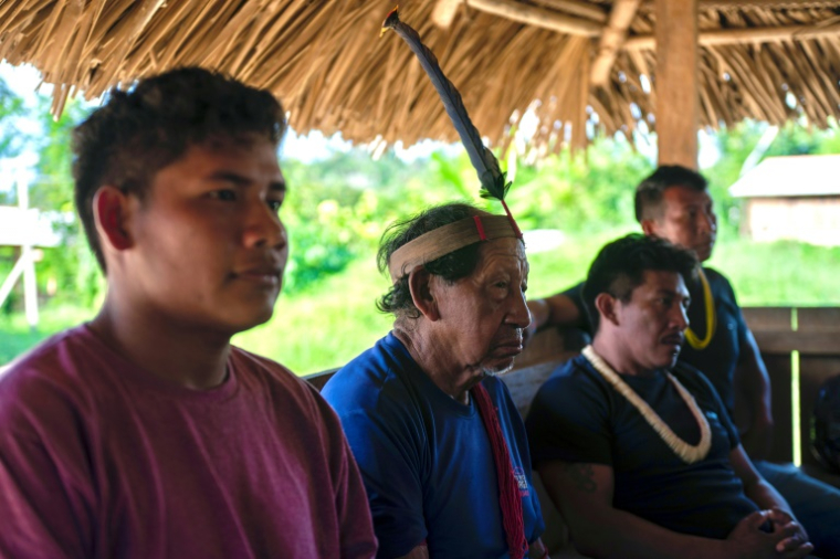 Takamyi Asurini (2e g) assiste à une réunion des dirigeants indigènes au village d'Ita'aka, dans le territoire indigène de Koatinemo, dans l'État de Para, au Brésil, le 12 juin 2025 ( AFP / Carlos Fabal )