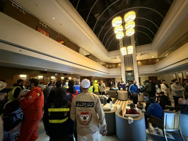 Des secouristes dans le hall d'entrée de l'hôtel Ramada touché par une frappe israélienne, le 8 mars 2026 à Beyrouth  ( AFP / Ibrahim AMRO )