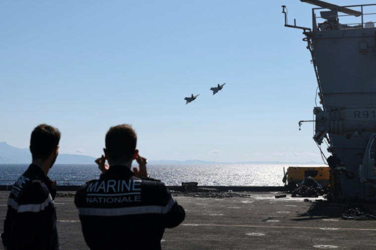 Deux avions de combat Rafale effectuent une passe à basse altitude au-dessus du porte-avions le 10 juillet 2026 ( AFP / Pascal POCHARD-CASABIANCA )