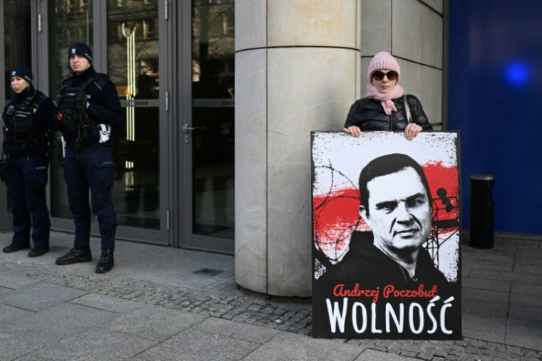 Une femme tient une pancarte avec le portrait du prisonnier Andrzej Poczobut, membre de la minorité polonaise du Belarus et correspondant de la Gazeta Wyborcza, devant le bureau du Parlement européen à Varsovie, le 14 mars 2024 ( AFP / Sergei GAPON )