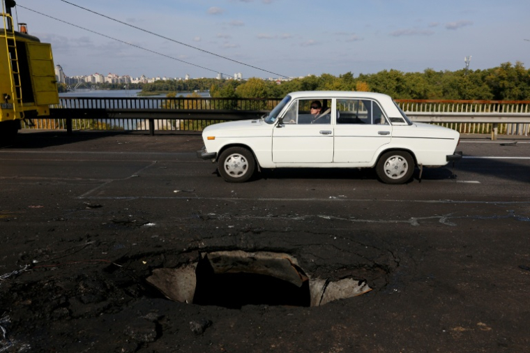 Une voiture passe sur un pont à Kiev, endommagé par une frappe de drone russe, le 4 octobre 2026 ( AFP / Mykola TYMCHENKO )