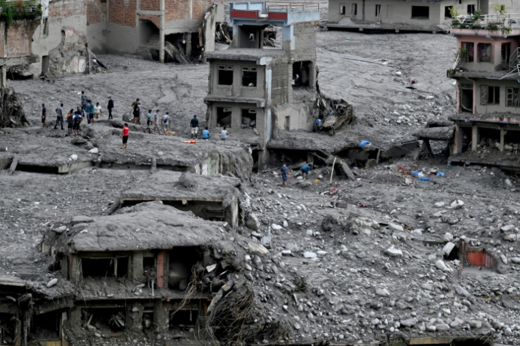 Des habitants parmi les décombres après la crue dévastatrice qui a ravagé leur ville de Nuwakot, au Népal, le 1er septembre 2026 ( AFP / Arun SANKAR )