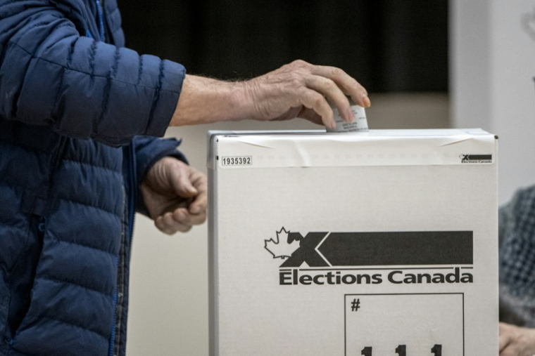 Une personne vote dans la circonscription de Terrebonne, au Québec, le 13 avril 2026 ( AFP / ANDREJ IVANOV )