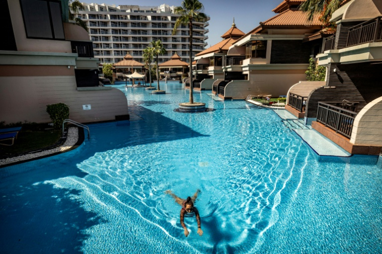 Une femme nage dans la piscine de l'hôtel Anantara The Palm à Dubaï, le 6 juin 2026 ( AFP / FADEL SENNA )