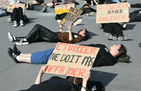 Des manifestants brandissent de pancartes dénonçant la pauvreté étudiante, à Paris le 18 avril 2025 ( AFP / Bertrand GUAY )