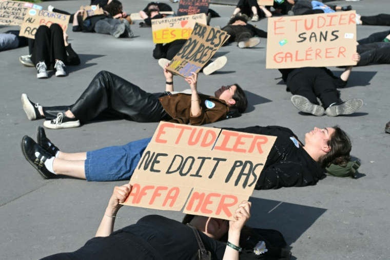 Des manifestants brandissent de pancartes dénonçant la pauvreté étudiante, à Paris le 18 avril 2025 ( AFP / Bertrand GUAY )