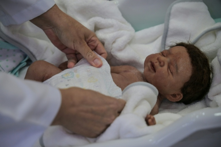 La commerçante Alana Generoso met une couche à un bébé "reborn" dans sa boutique Maternité Alana Babys à Campinas, dans l'État de Sao Paulo, au Brésil, le 16 mai 2025 ( AFP / NELSON ALMEIDA )
