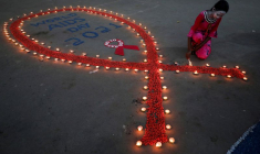 Une jeune fille allume des lampes en terre lors d'une campagne de sensibilisation au VIH/SIDA