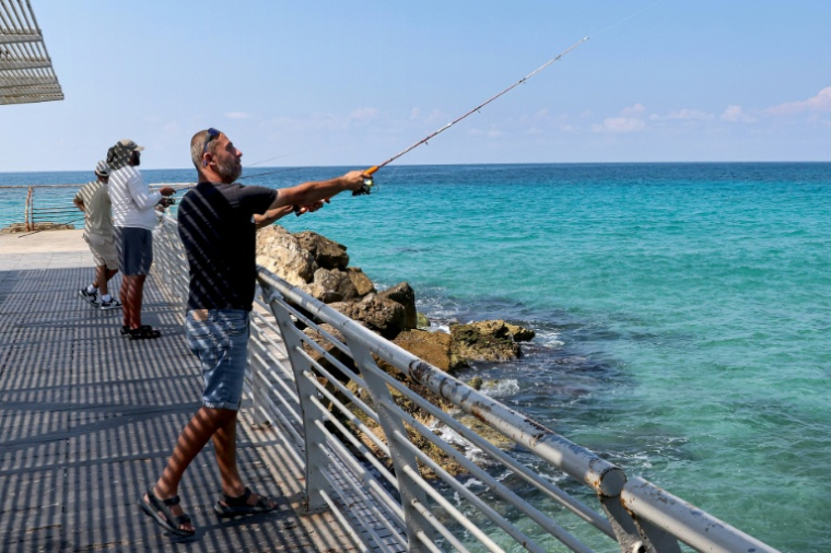 Maxim Zarbaylov, un habitant de Nahariya, dans le nord d'Israël, en train de pêcher dans la Méditerranée, le 24 septembre 2026 ( AFP / JACK GUEZ )