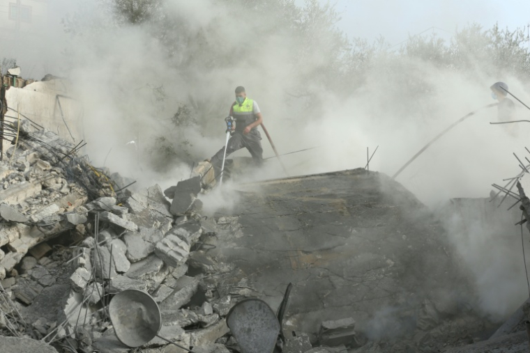 Des membres de la défense civile éteignent un feu après une frappe israélienne dans le village d'Ain Qana, au sud du Liban, le 2 février 2026 ( AFP / MAHMOUD ZAYYAT )