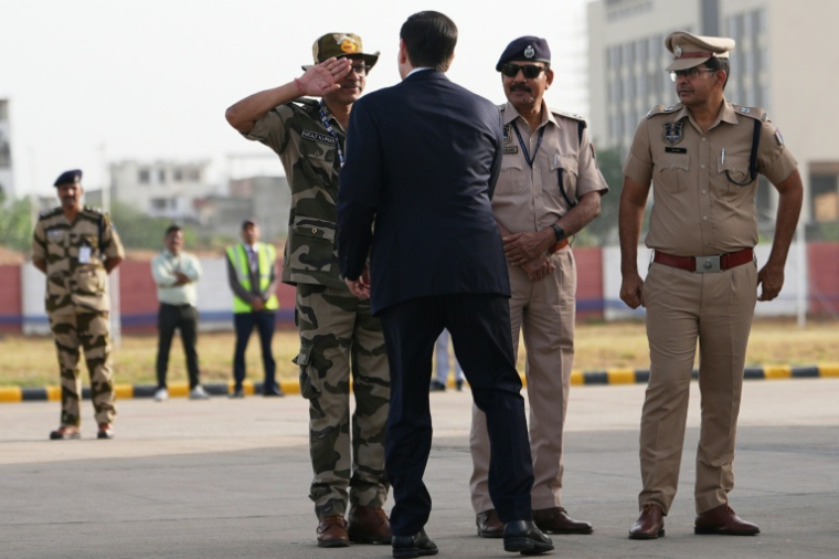 Un responsable indien de la sécurité salue le secrétaire d'Etat américain Marco Rubio avant que celui-ci ne monte à bord de son avion à l'aéroport international de Jaipur, en Inde, le 26 mai 2026 ( POOL / Julia Demaree Nikhinson )