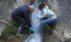Des membres de l'association "Future Generations" récoltent des échantillons dans les eaux rejetées par l'usine Solvay de Salindres, le 18 avril 2024. ( AFP / PASCAL GUYOT )