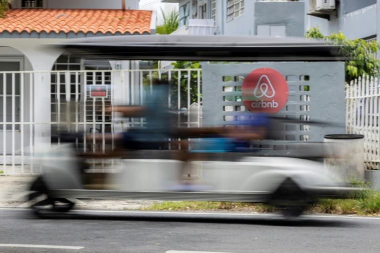 Une voiturette de golf passe devant une villa en Airbnb à Vega Baja, le 13 Juillet 2025 à Porto Rico ( AFP / Ricardo ARDUENGO )