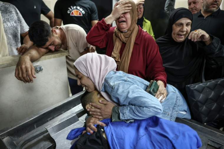 La femme du Palestinien Ali al-Bazzari, tué dans une attaque de colons en peline récolte des olives, étreint son corps dans un hôpital de la ville de Naplouse, le 7 octobre 2026 ( AFP / Zain JAAFAR )