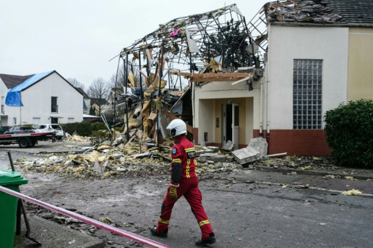 Un pompier devant un pavillon détruit par une explosion à Magny-les-Hameaux, le 23 décembre 2025 dans les Yvelines ( AFP / Dimitar DILKOFF )