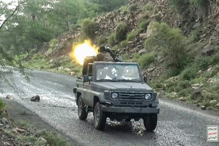 Image tirée d'une vidéo publiée par le centre médiatique d'Ansarullah le 7 octobre 2026 montrant un combattant houthi tirant avec une mitrailleuse montée sur un camion lors d'une progression contre les troupes du gouvernement yéménite dans la région de Taëz, selon les médias houthis ( ANSARULLAH MEDIA CENTRE / Handout )