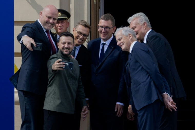 Le président ukrainien Volodymyr Zelensky fait un selfie, entouré du Premier ministre letton Andris Kulbergs, du président finlandais Alexander Stubb, du Premier ministre estonien Kristen Michal, du Premier ministre norvégien Jonas Gahr Store et du président lituanien Gitanas Nauseda (de gauche à droite), à Kiev le 23 août 2026 ( AFP / Tetiana DZHAFAROVA )
