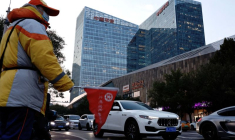 Un agent de circulation guide le flux de la circulation près du Ping An International Financial Center à Pékin