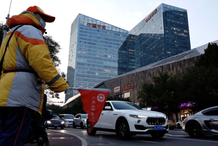 Un agent de circulation guide le flux de la circulation près du Ping An International Financial Center à Pékin