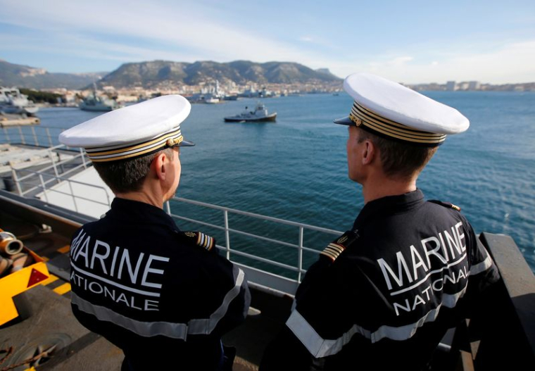 Des marins de la marine française se tiennent sur le pont alors que le porte-avions Charles de Gaulle quitte la base navale de Toulon, en France