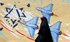 Une Iranienne marche devant une fresque anti-américaine et anti-israélienne, le 8 avril 2026 à Téhéran ( AFP / ATTA KENARE )