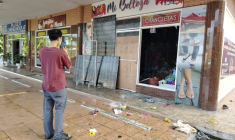 Un homme prend des photos des dégâts dans un magasin après des pillages et de violentes manifestations à Changuinola, au Panama, le 20 juin 2025 ( AFP / DANIEL SANTOS )