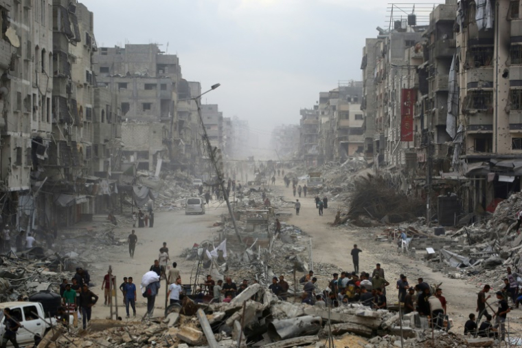 Des Palestiniens marchent au milieu de bâtiments détruits dans la ville de Gaza, le 12 octobre 2025, au troisième jour d'un cessez-le-feu entre Israël et le Hamas palestinien ( AFP / Bashar TALEB )