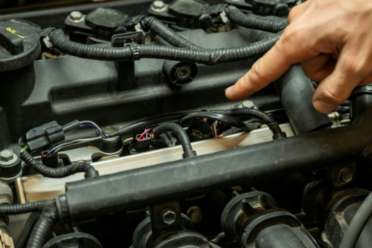 Le câblage reliant un boîtier de conversion au bioéthanol aux injecteurs de carburant d'un moteur, dans un garage à Marseille, le 18 septembre 2026 ( AFP / Miguel MEDINA )