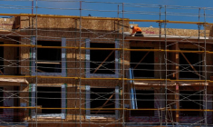 Un ouvrier du bâtiment travaille sur un projet de logements résidentiels à plusieurs unités à Encinitas, en Californie