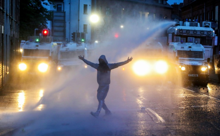 La police utilise un canon à eau pour disperser les manifestants lors d'une troisième nuit d'émeutes visant les immigrés à Ballymena, en Irlande du Nord, le 11 juin 2025 ( AFP / PAUL FAITH )