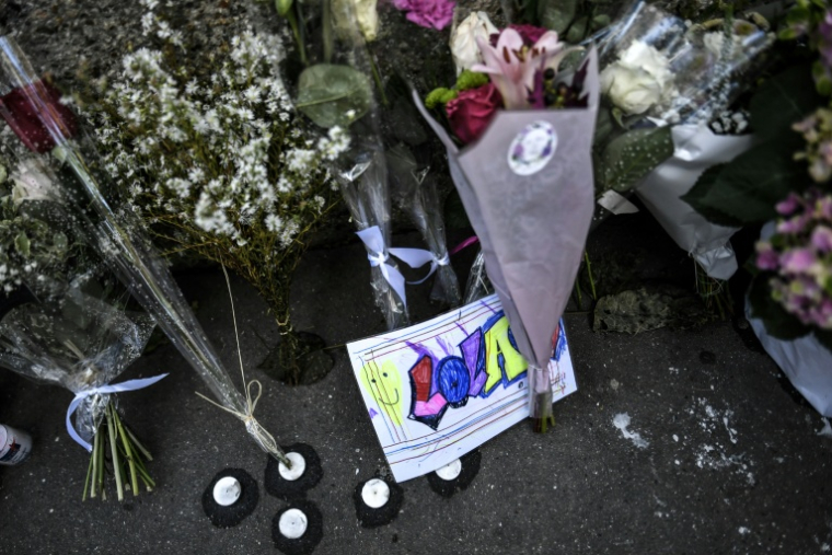 Des fleurs et des messages déposés devant l'immeuble où résidait Lola, le 20 octobre 2022 à Paris ( AFP / STEPHANE DE SAKUTIN )