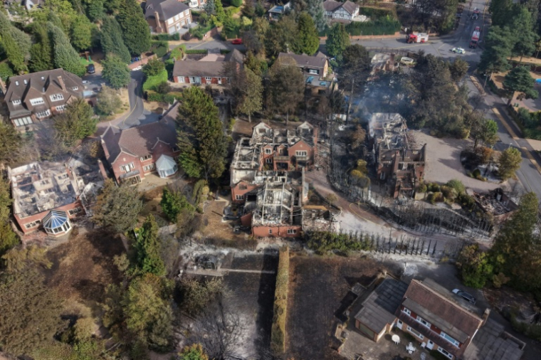 De la fumée s'élève de maisons endommagées par un incendie, au sud de Stourbridge, dans le centre de l'Angleterre, le 14 août 2026 ( AFP / Darren Staples )