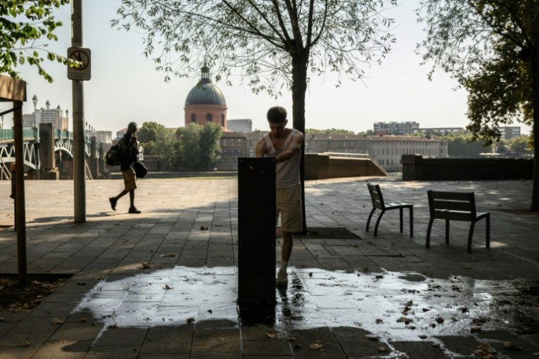 Un homme se sert de l'eau à une fontaine de Toulouse, le 15 août 2025 ( AFP / Ed JONES )