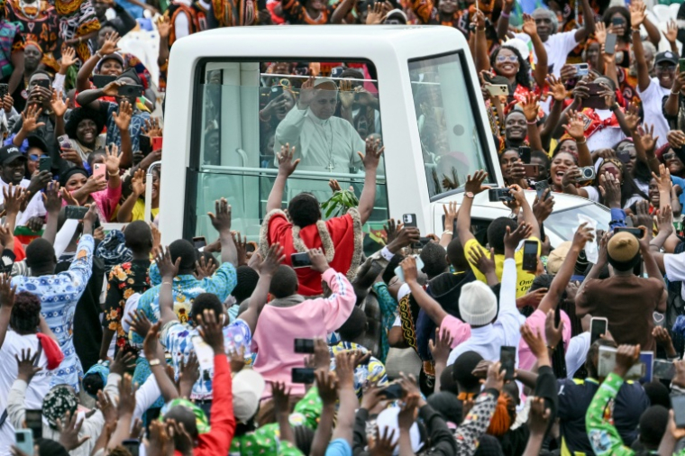 Le pape Léon XIV (c) salue la foule depuis sa papamobile à son arrivée à l'aéroport de Bamenda pour célébrer une messe, le 16 avril 2026 au Cameroun ( AFP / Alberto PIZZOLI )