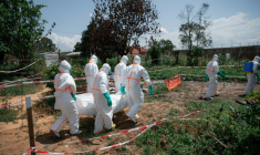 Des bénévoles de la Croix-Rouge, en combinaison de protection, transportent le corps d'une victime de la maladie à virus Ebola au centre de santé de Rwampara, le 8 juin 2026 en RDC ( AFP / Jospin Mwisha )