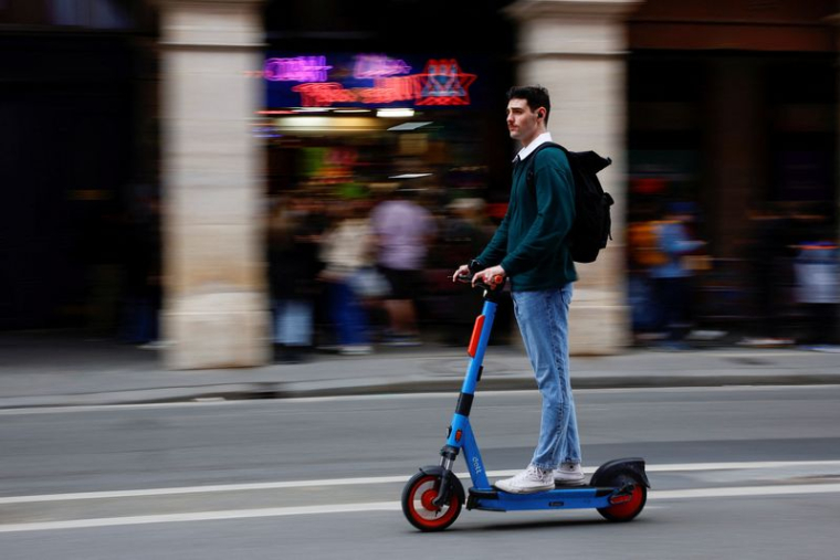 Un homme monte une trottinette électrique à Paris, France