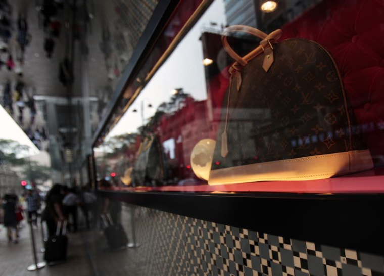 Des sacs exposés dans la vitrine d'un magasin Louis Vuitton dans le quartier commerçant de Tsim Sha Tsui à Hong Kong