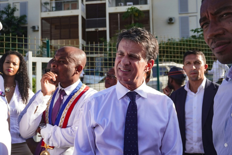 Le ministre des Outre-mer, Manuel Valls et le maire de Mamoudzou Ambdilwahedou Soumaila visitent un bâtiment de la Société immobilière de Mayotte en cours de reconstruction à Passamainty dans la commune de Mamoudzou à Mayotte, le 8 avril 2025 ( AFP / Marine GACHET )