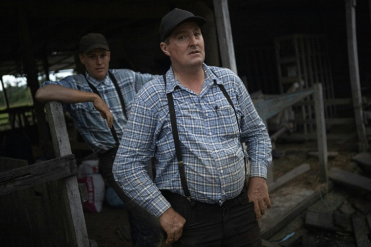Le mennonite Davis Klassen, 45 ans, pose pour une photo avec son fils à Masisea, département d'Ucayali, Pérou, le 20 mars 2025 ( AFP / ERNESTO BENAVIDES )