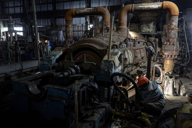 Des employés travaillent dans une centrale thermique endommagée par des frappes de missiles russes, en Ukraine