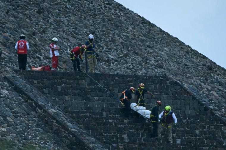 Des experts médico-légaux et des membres de la Croix-Rouge transportent un corps sur la pyramide de la Lune, sur le site archéologique de Teotihuacan, après une fusillade survenue à Teotihuacan, dans l'Etat de Mexico, le 20 avril 2026 ( AFP / YURI CORTEZ )