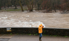 Un passant sur les berges de l'Hérault, qui a débordé suite aux fortes pluies à Laroque, le 22 décembre 2025 ( AFP / Sylvain THOMAS )